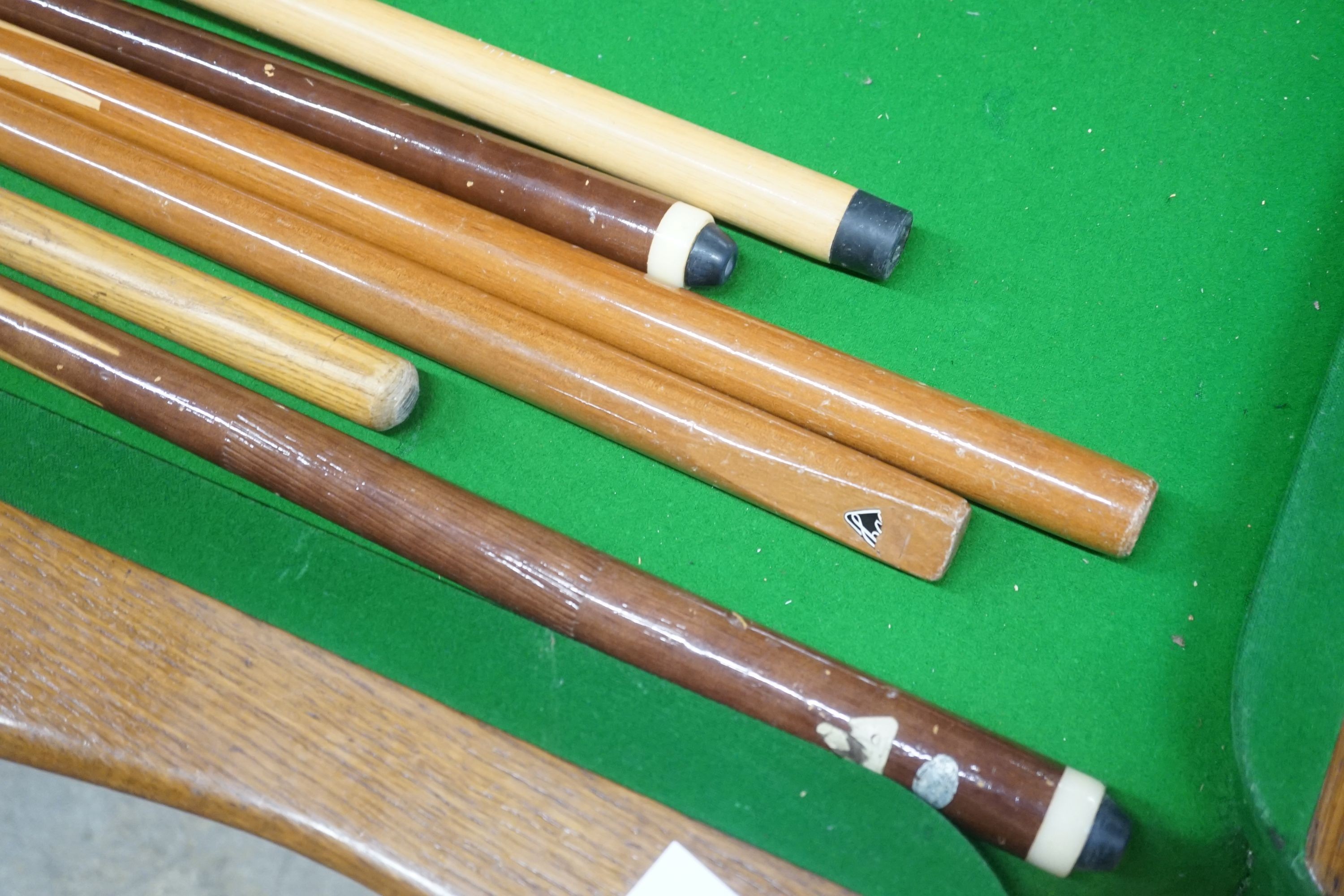 An early 20th century oak snooker / dining table, of rectangular serpentine form, with rise and fall action and full accessories, width 200cm depth 110cm height 74cm